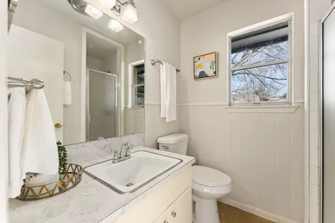 a bathroom with a sink toilet and a mirror