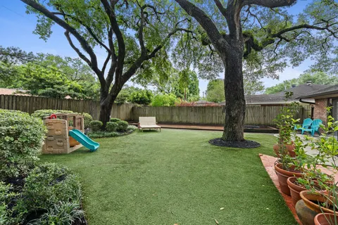 a view of a house with a backyard and a tree