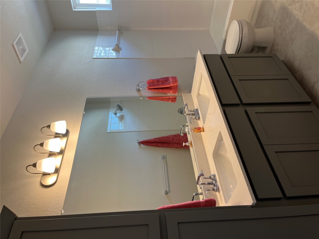 130 Spangle Way Kyle, TX 78640 - Photo 19 of 28 a bathroom with a double vanity sink and a mirror