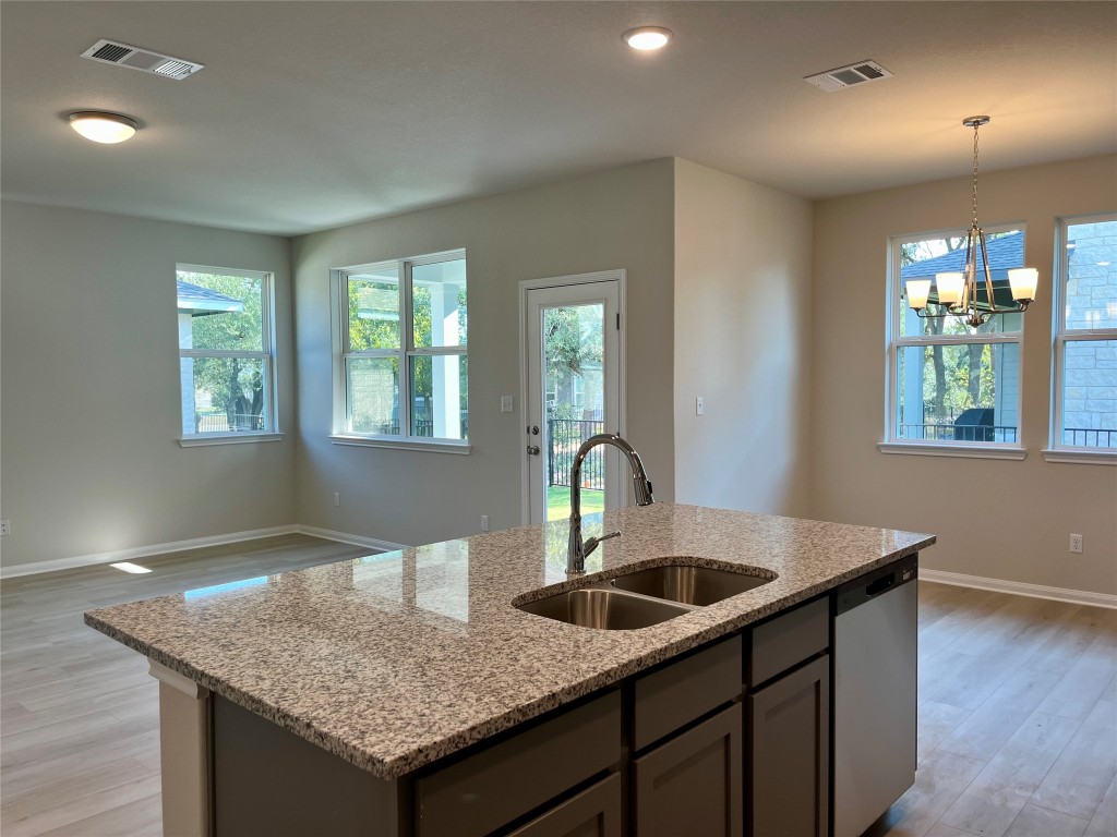 130 Spangle Way Kyle, TX 78640 - Photo 10 of 28 a kitchen with a sink a center island and wooden floor