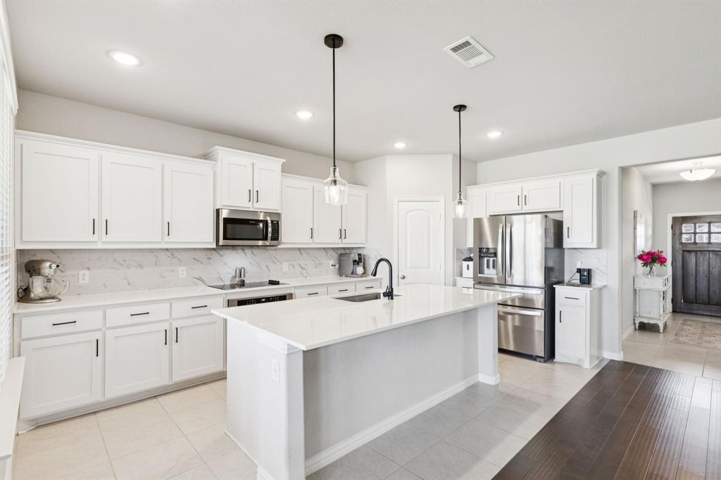 118 Mossy Creek Trail Rhome, TX 76078 - Photo 13 of 28 a kitchen with white cabinets and stainless steel appliances