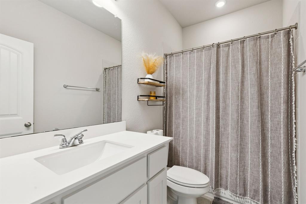 118 Mossy Creek Trail Rhome, TX 76078 - Photo 8 of 28 a bathroom with a sink a toilet and shower curtain