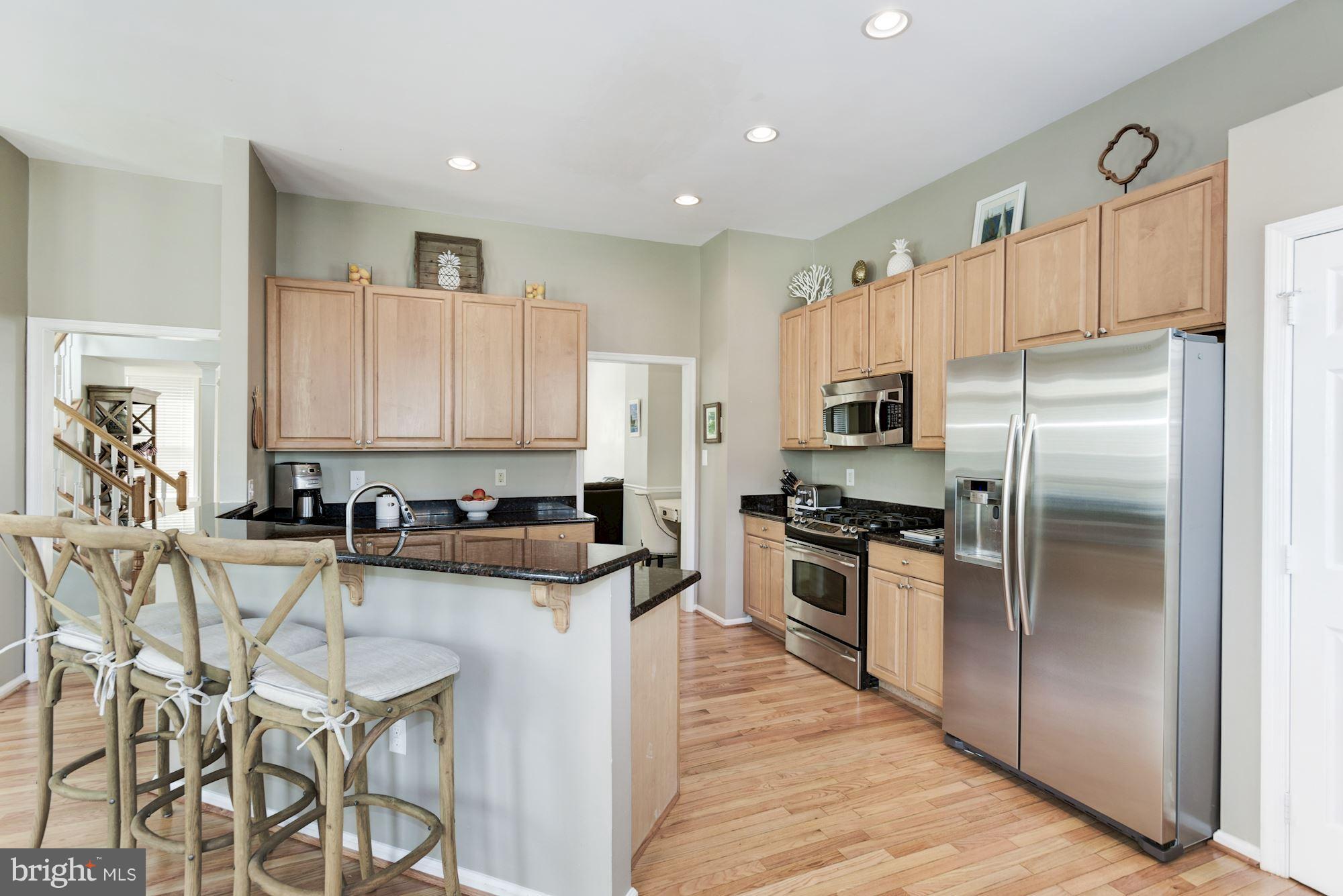20709 Riptide Square Sterling, VA 20165 - Photo 13 of 30 a kitchen with granite countertop stainless steel appliances a refrigerator and a stove top oven