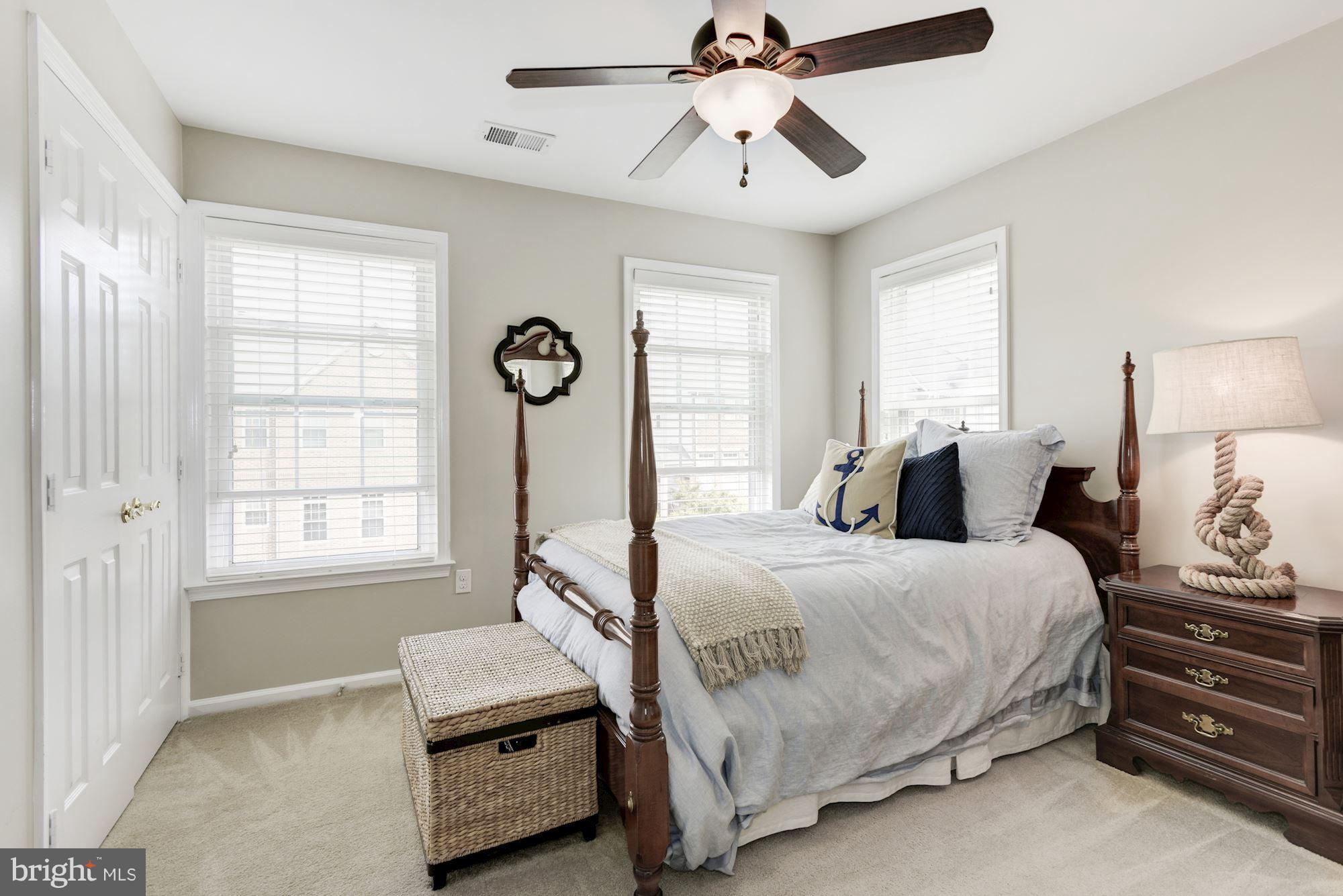 20709 Riptide Square Sterling, VA 20165 - Photo 20 of 30 a bedroom with a bed a chandelier and a window