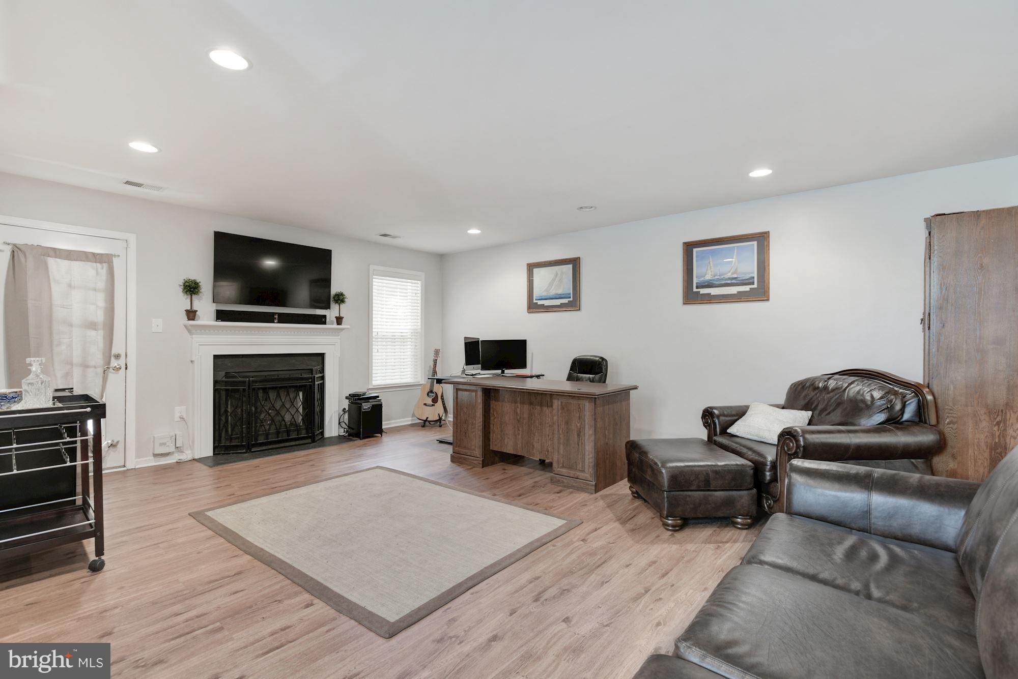 20709 Riptide Square Sterling, VA 20165 - Photo 25 of 30 a living room with furniture a fireplace a flat screen tv and kitchen view