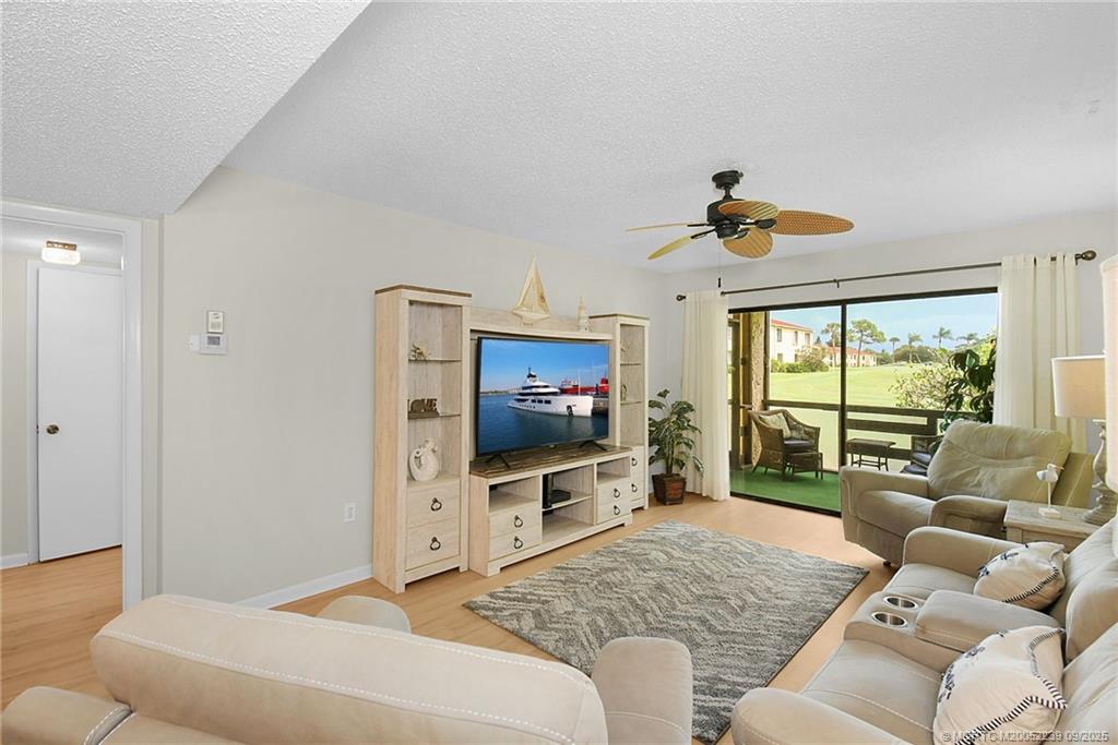 5313 Southeast Miles Grant Road, Unit 102 Stuart, FL 34997 - Photo 13 of 48 a living room with furniture and a flat screen tv