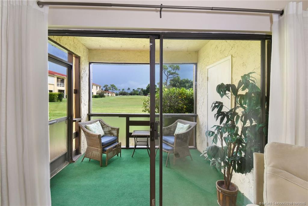 5313 Southeast Miles Grant Road, Unit 102 Stuart, FL 34997 - Photo 15 of 48 a porch with a table and chairs