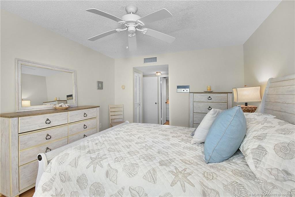 5313 Southeast Miles Grant Road, Unit 102 Stuart, FL 34997 - Photo 19 of 48 a bedroom with a large bed and a mirror