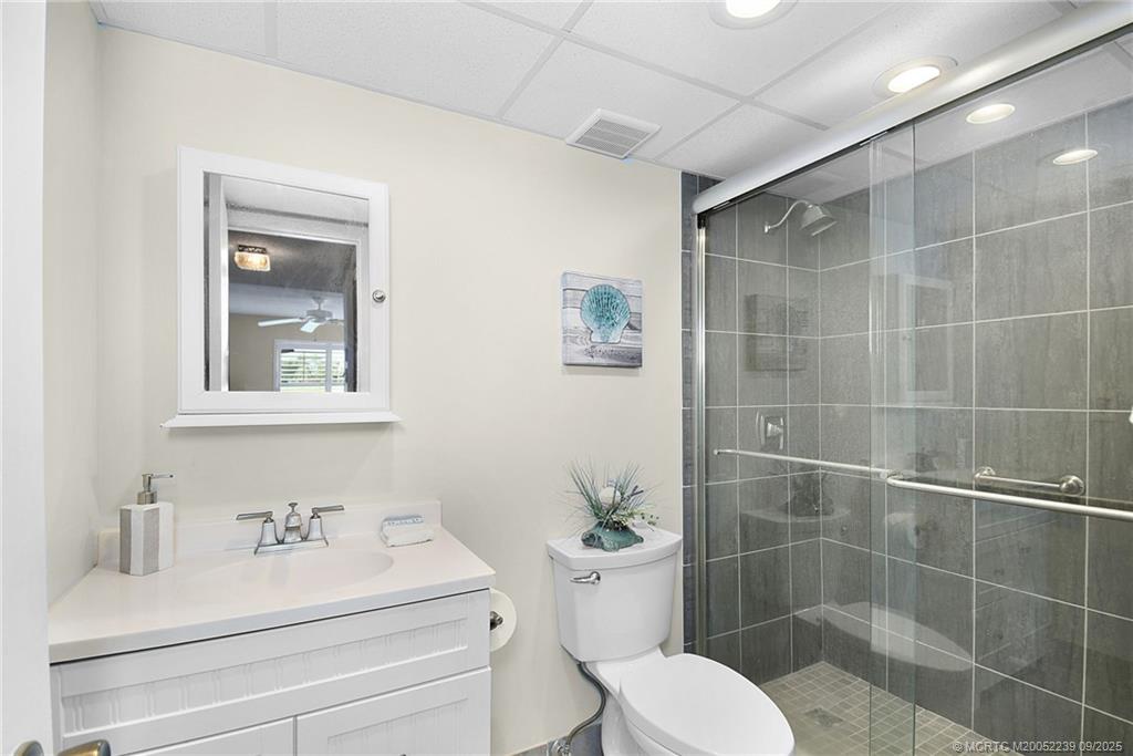 5313 Southeast Miles Grant Road, Unit 102 Stuart, FL 34997 - Photo 20 of 48 a bathroom with a sink a toilet and a mirror