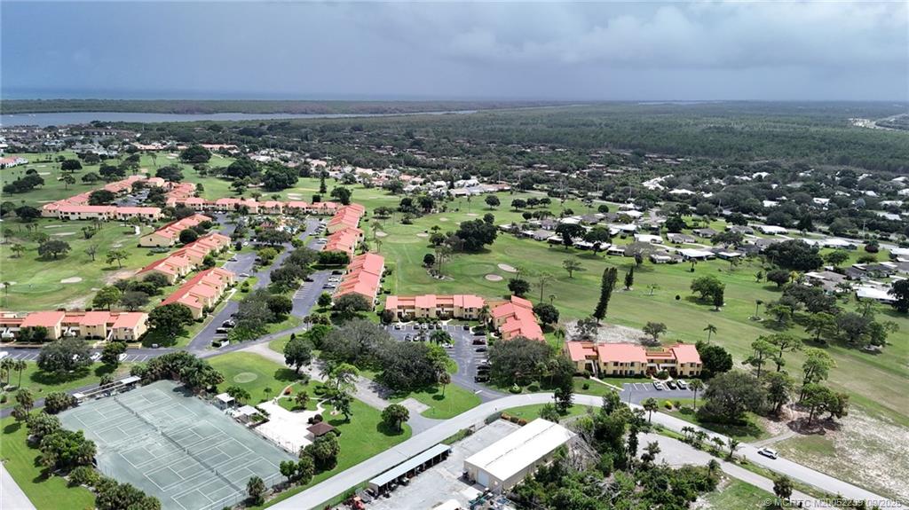5313 Southeast Miles Grant Road, Unit 102 Stuart, FL 34997 - Photo 25 of 48 an aerial view of a city with lots of residential buildings and mountain view in back