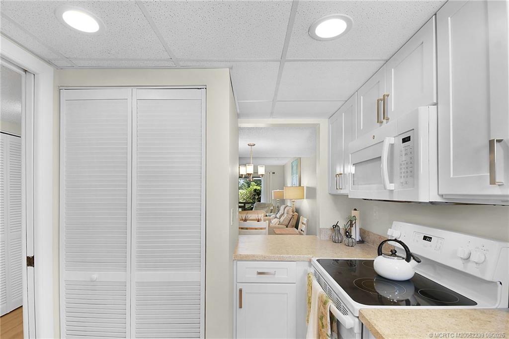 5313 Southeast Miles Grant Road, Unit 102 Stuart, FL 34997 - Photo 6 of 48 a kitchen with stainless steel appliances white cabinets and a sink