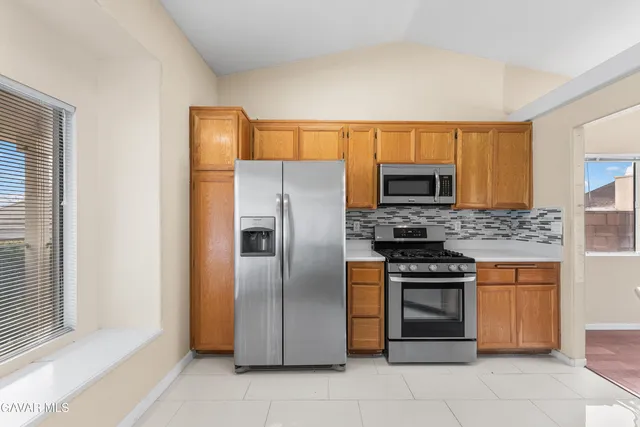 a kitchen with stainless steel appliances granite countertop a refrigerator and a stove top oven