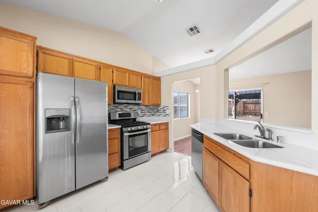 a kitchen with stainless steel appliances granite countertop a sink stove and refrigerator