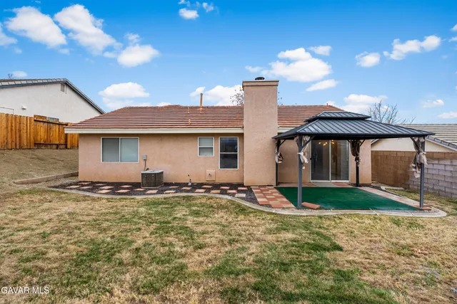 a view of a backyard with table and chairs with wooden floor and fence