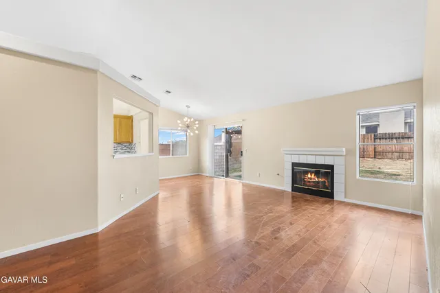 a view of an empty room with a fireplace and a window