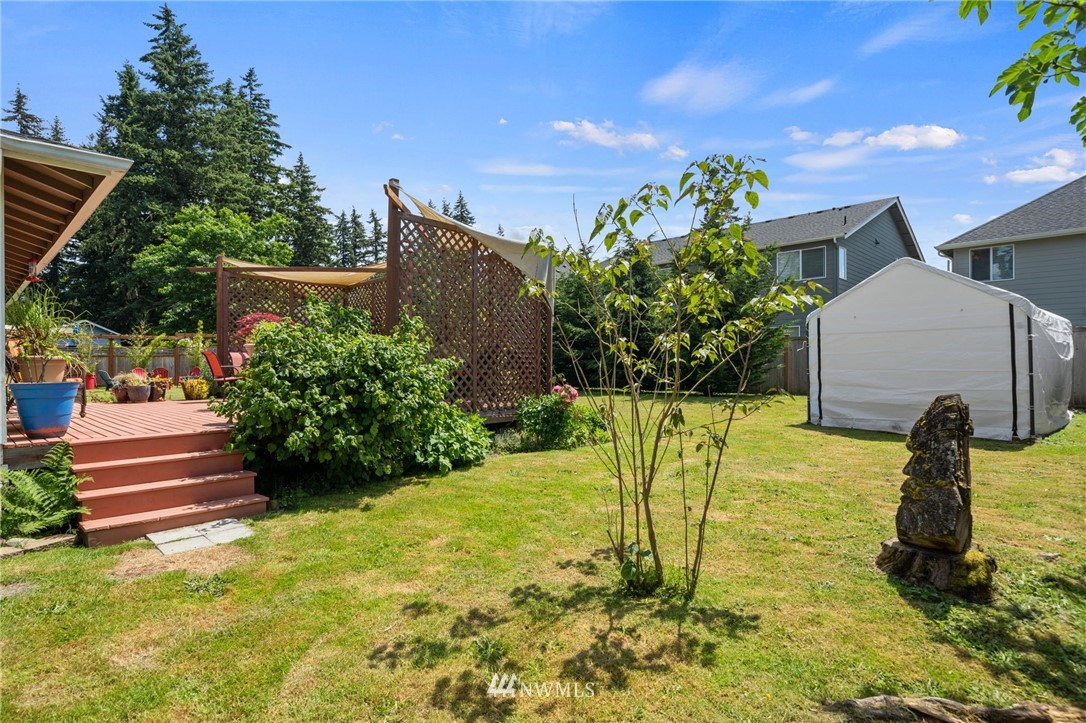 128 183rd Street Southwest Bothell, WA 98012 - Photo 28 of 33 a backyard of a house with table and chairs plants and large tree