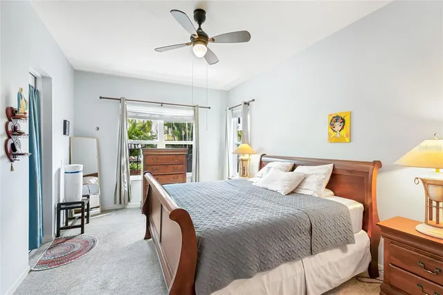 a bedroom with a bed a dresser and a chandelier