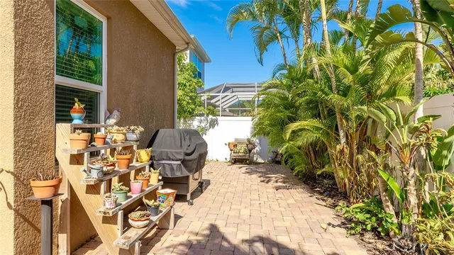 a patio with table and chairs and potted plants