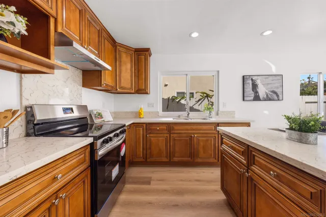 a kitchen with stainless steel appliances granite countertop a stove and a sink