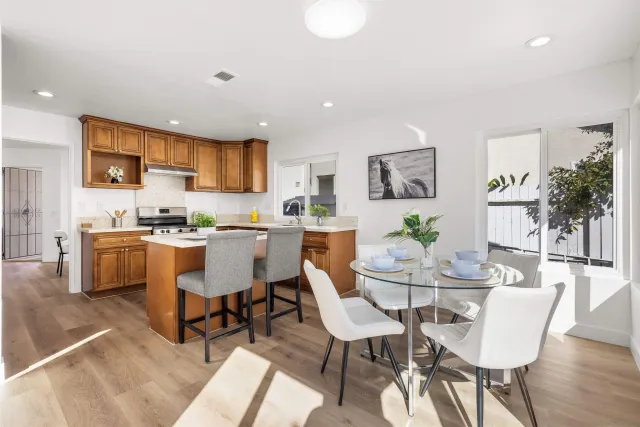 a kitchen with stainless steel appliances kitchen island granite countertop a dining table and chairs