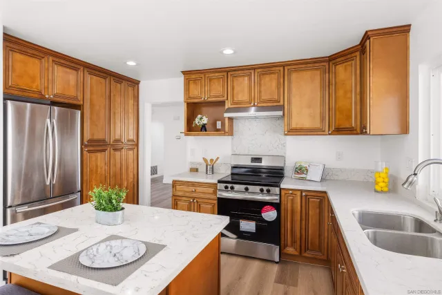 a kitchen with a sink a stove and cabinets