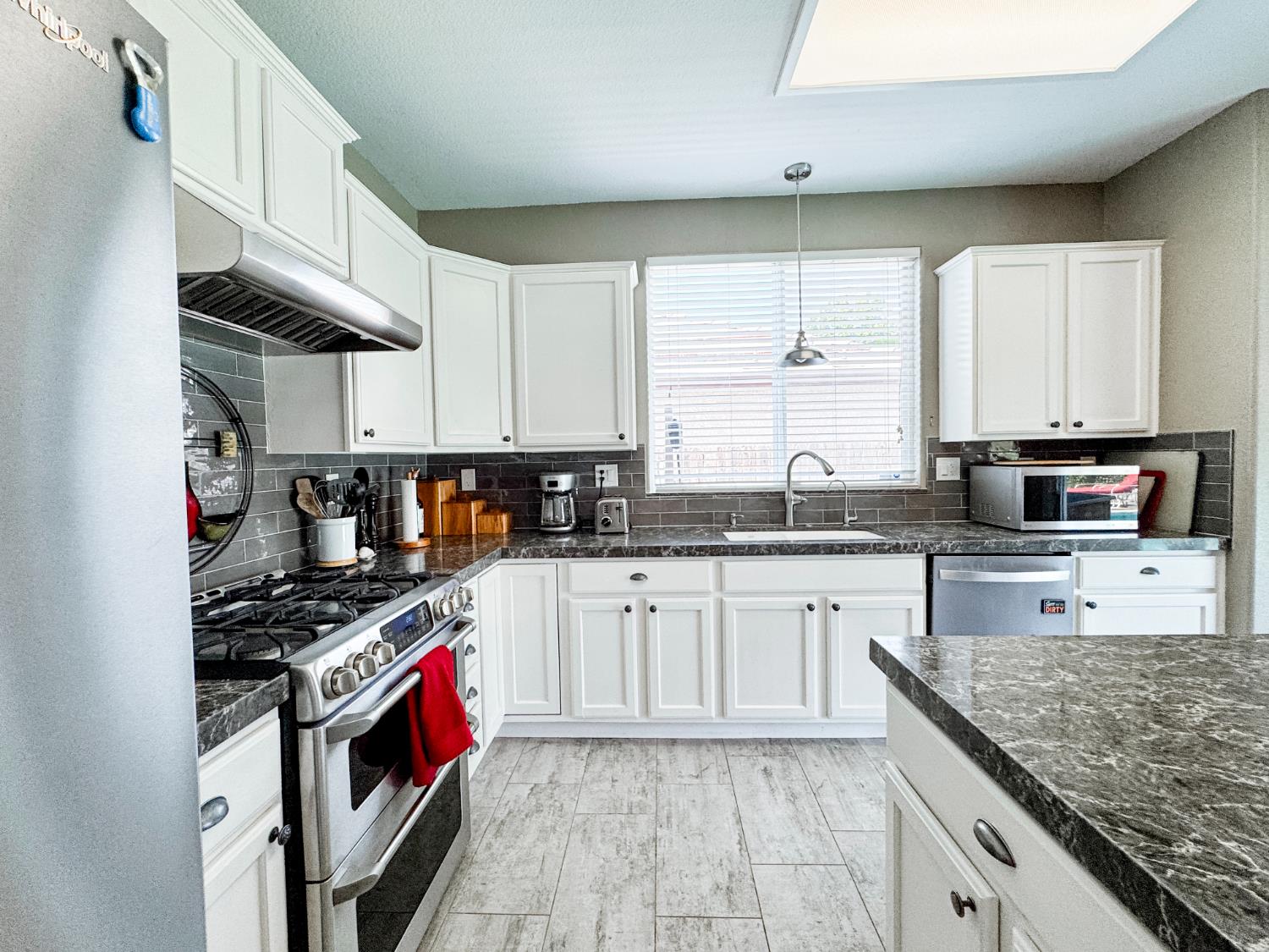 2457 Carson Avenue Clovis, CA 93611 - Photo 9 of 33 a kitchen with stainless steel appliances granite countertop a stove sink and cabinets