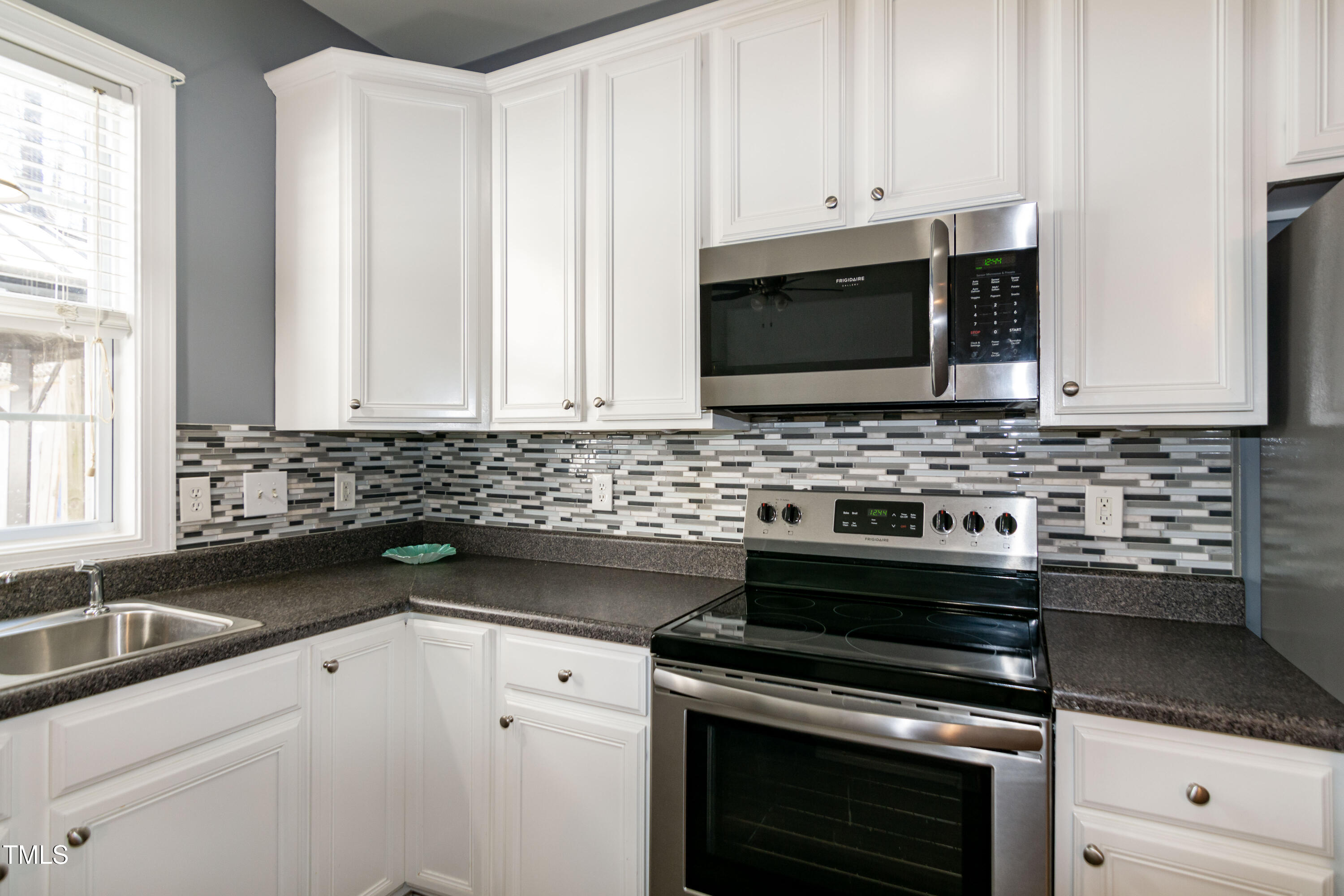 2638 Andover Glen Road Raleigh, NC 27604 - Photo 21 of 49 a kitchen with granite countertop white cabinets stainless steel appliances and sink