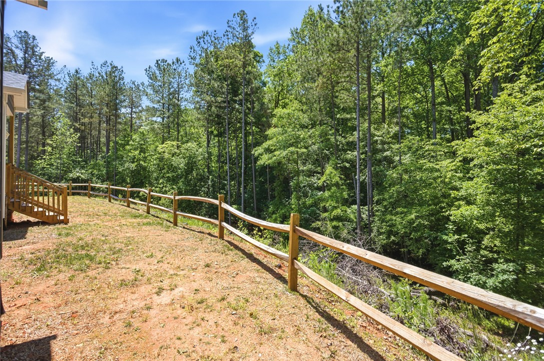 912 Watercrest Road West Union, SC 29696 - Photo 38 of 49 This verdant outdoor space offers a natural retreat with mature trees and a charming wooden fence.