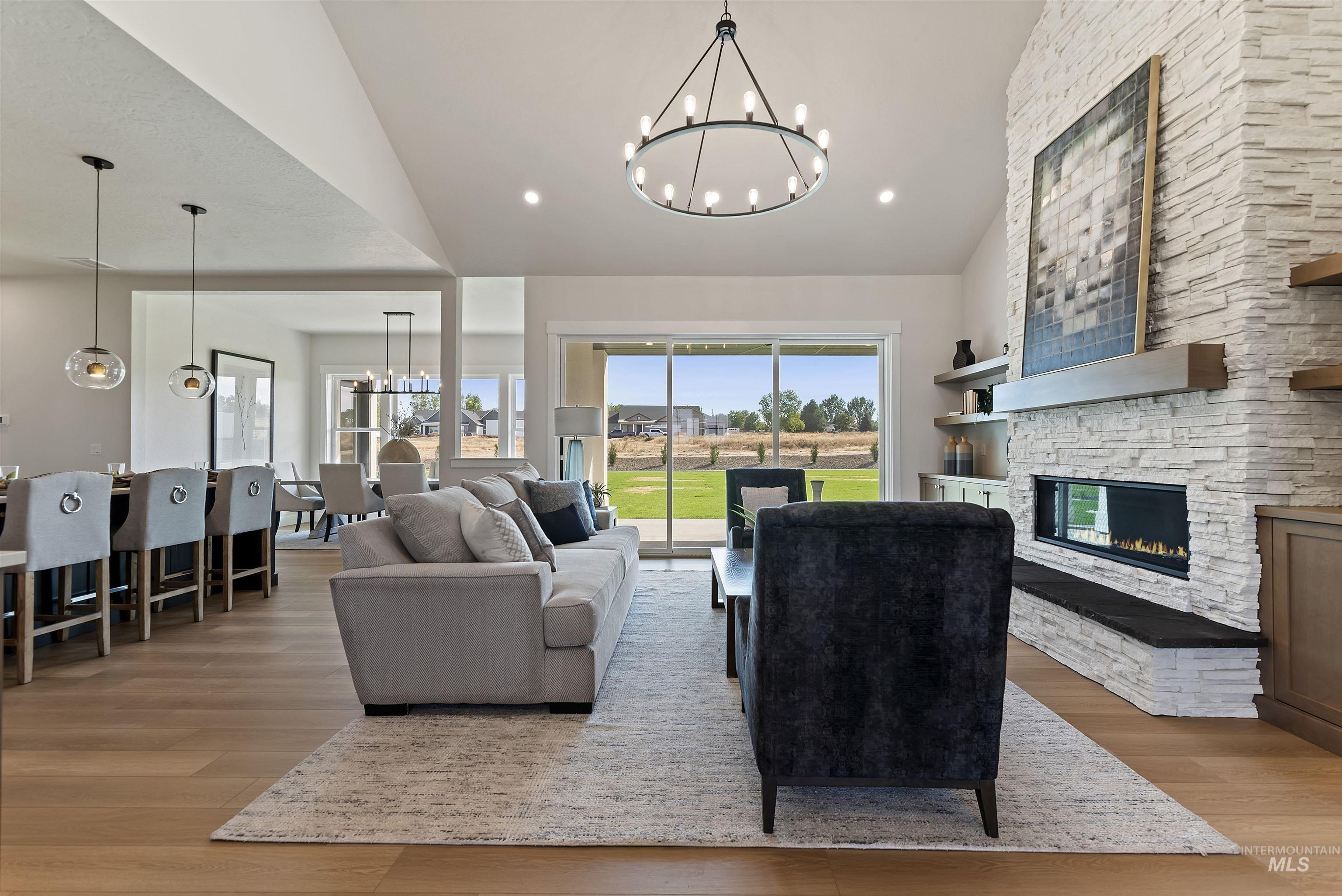 24864 Ardmore Court Caldwell, ID 83607 - Photo 13 of 48 Living area featuring a chandelier, a fireplace, light wood finished floors, recessed lighting, and high vaulted ceiling