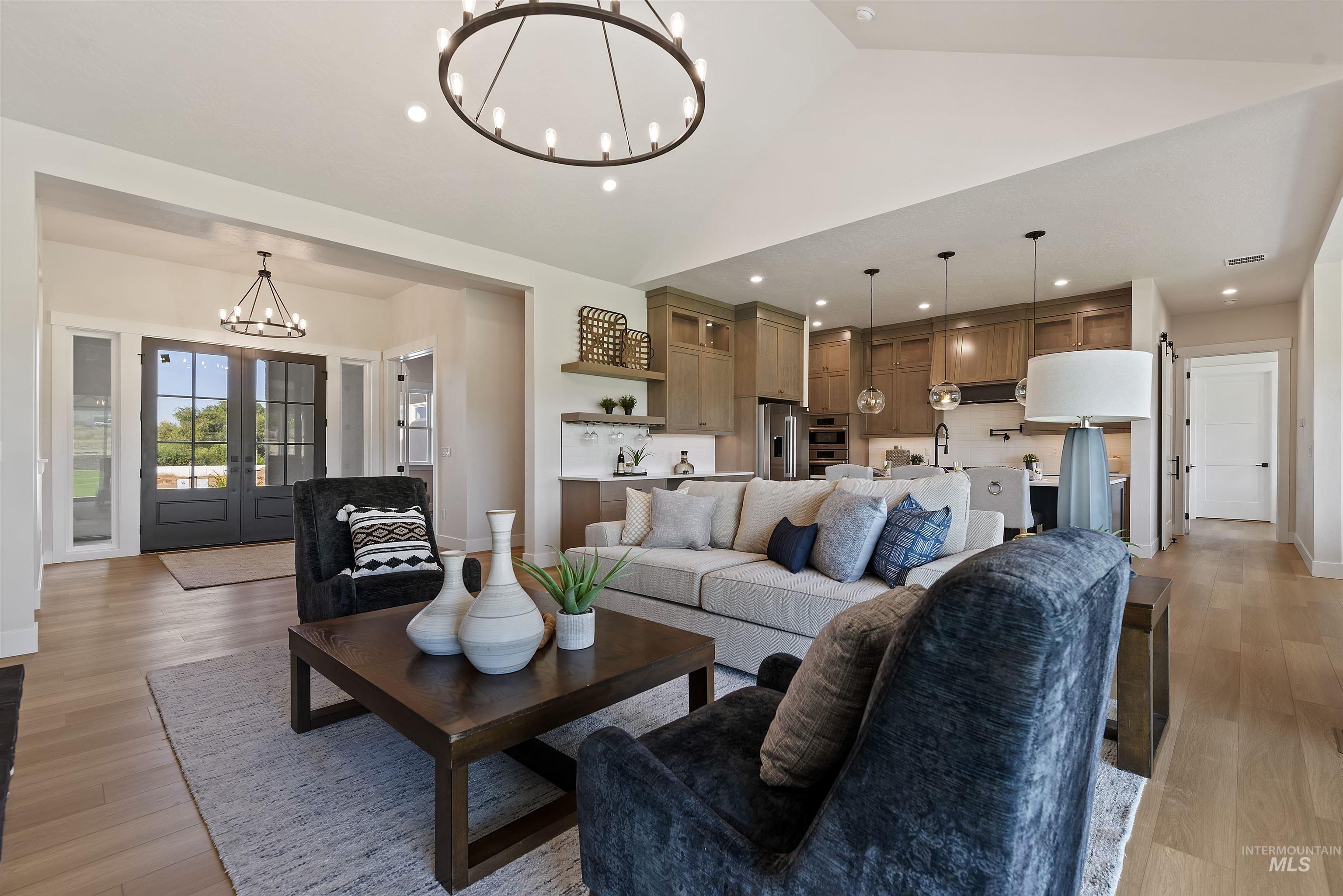 24864 Ardmore Court Caldwell, ID 83607 - Photo 15 of 48 Living area with a chandelier, french doors, light wood-style flooring, recessed lighting, and lofted ceiling