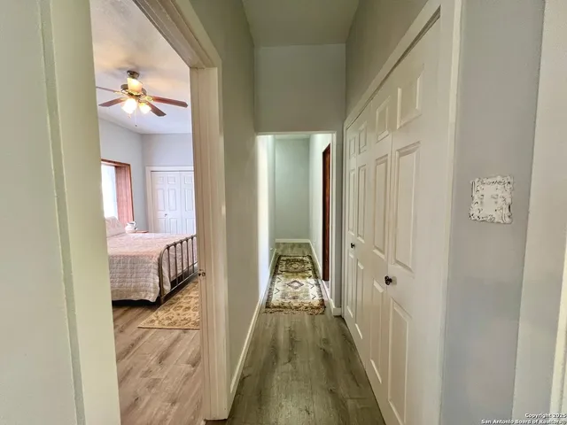a view of a hallway with wooden floor and closet