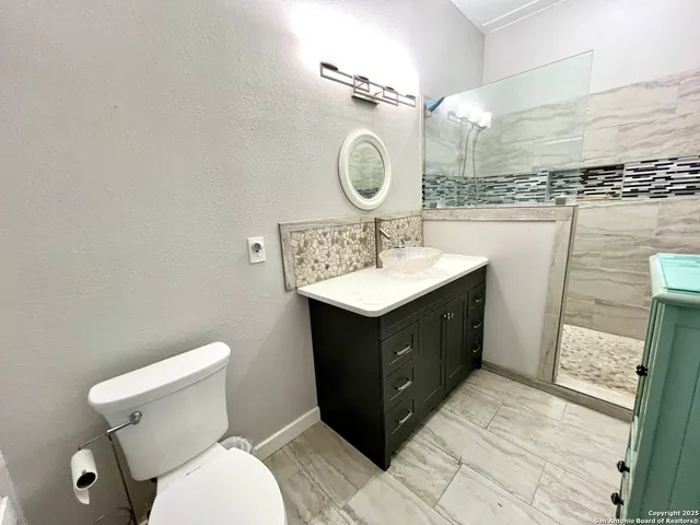 a bathroom with a toilet a sink a mirror and vanity