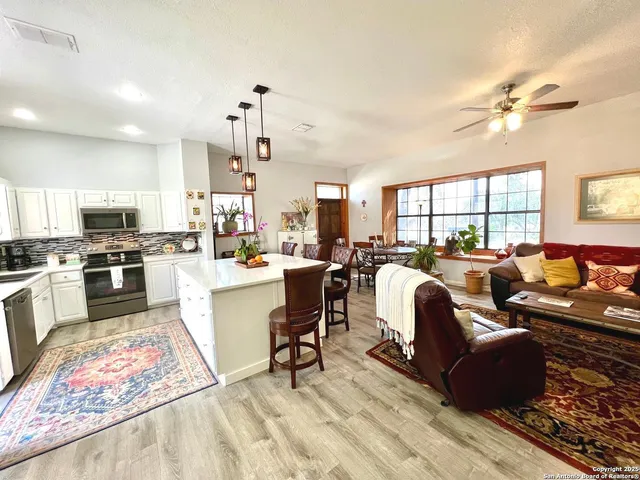 a living room with furniture a dining table and kitchen view