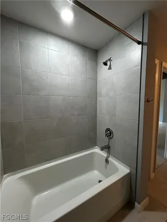 a white bath tub sitting next to a shower