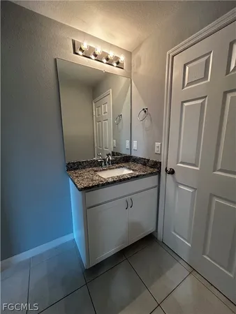 a bathroom with a granite countertop sink and a mirror