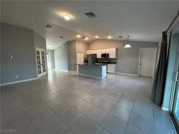 a large hall with stainless steel appliances a sink and a counter top space
