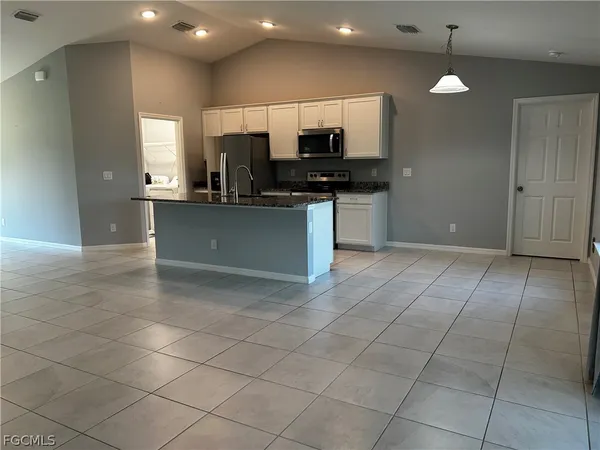 a kitchen with stainless steel appliances kitchen island granite countertop a sink and cabinets