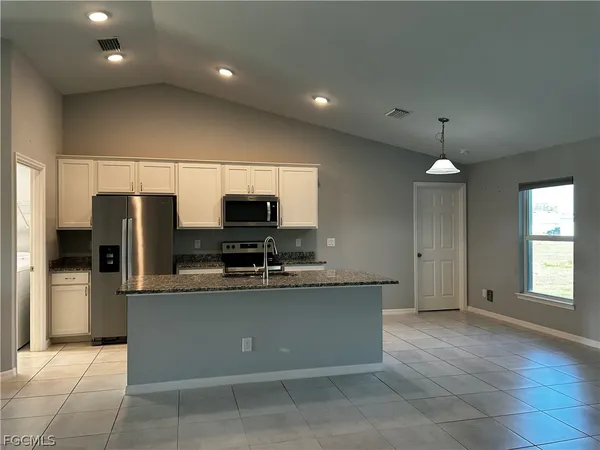 a large kitchen with a large counter top stainless steel appliances and cabinets