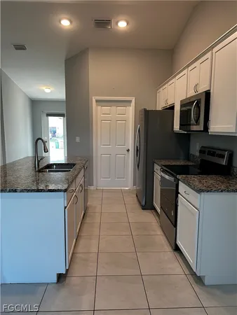 a kitchen with stainless steel appliances granite countertop a refrigerator and a stove
