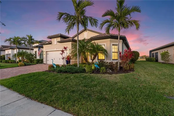 a view of a house with a yard and palm trees