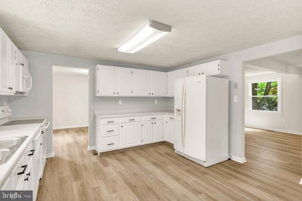 10640 Gorman Road Laurel, MD 20723 - Photo 9 of 25 a kitchen with white cabinets and wooden floor