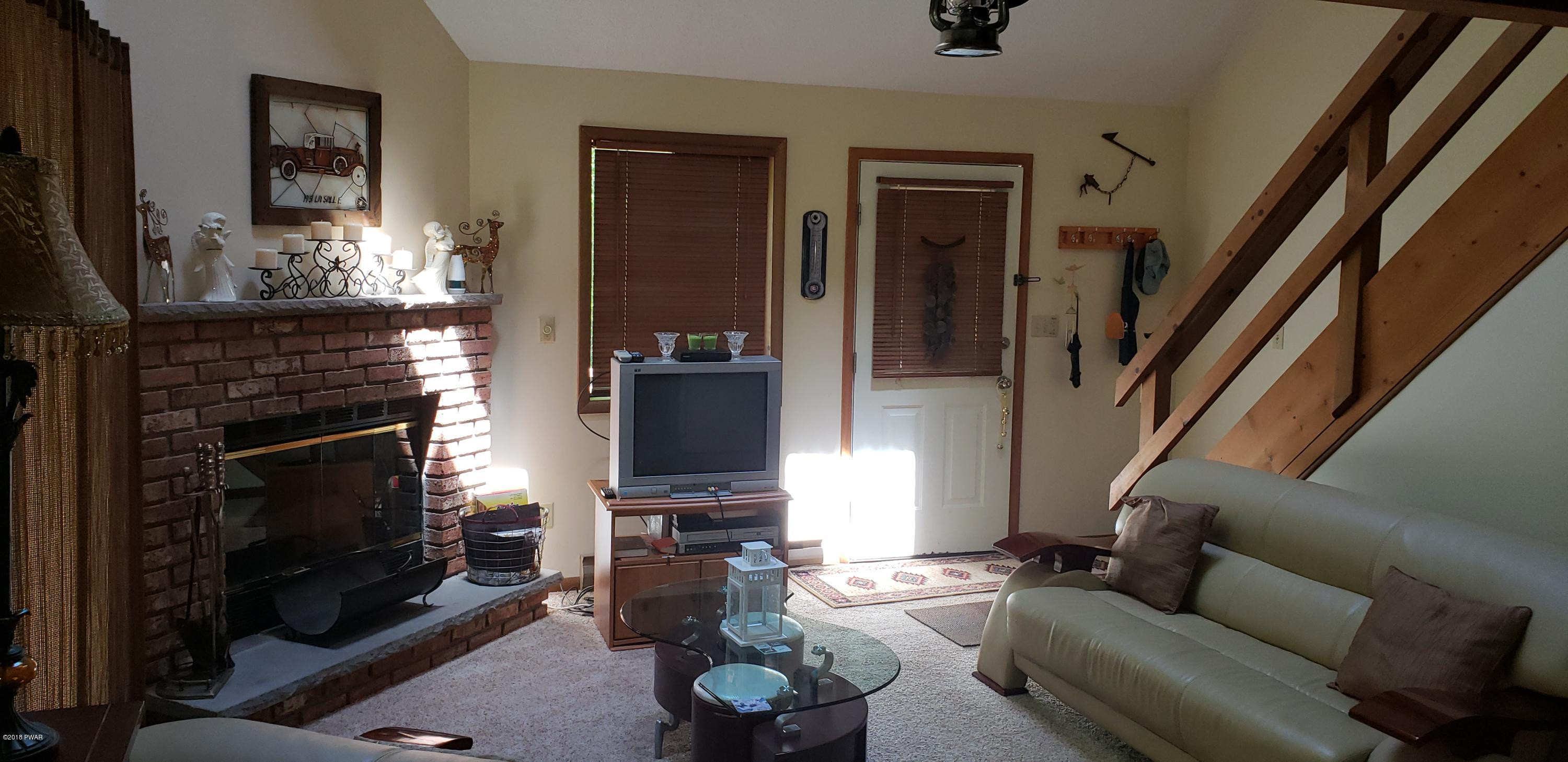 2597 Boulder Road Lake Ariel, PA 18436 - Photo 7 of 27 a living room with furniture a fireplace and a flat screen tv