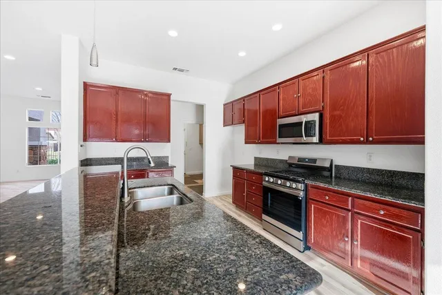 a kitchen with stainless steel appliances granite countertop a stove microwave and cabinets