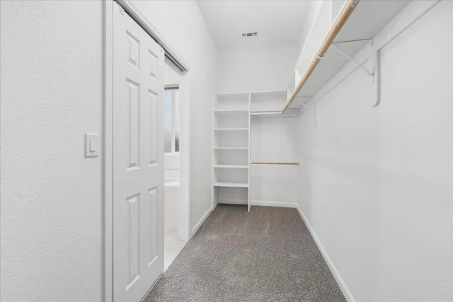 a view of walk in closet with empty racks