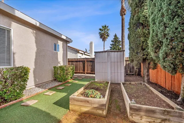 a view of a backyard with plants and a patio