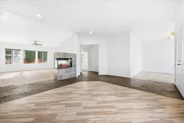 a bedroom with a bed and a dresser with wooden floor