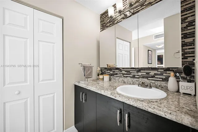 a bathroom with a granite countertop sink and a mirror
