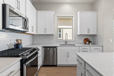 a kitchen with cabinets appliances and a window