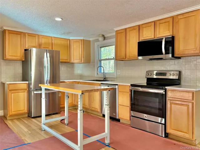 a kitchen with stainless steel appliances granite countertop a stove microwave and refrigerator