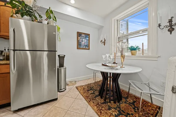 a kitchen with a refrigerator a table and chairs